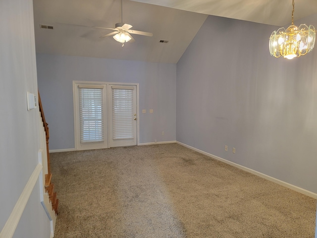 carpeted spare room featuring ceiling fan with notable chandelier and vaulted ceiling