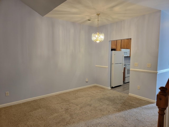 empty room with light colored carpet and an inviting chandelier