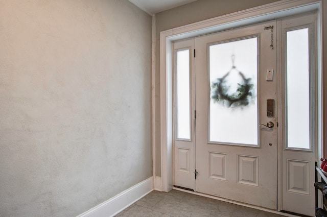 foyer featuring light tile patterned flooring and a wealth of natural light