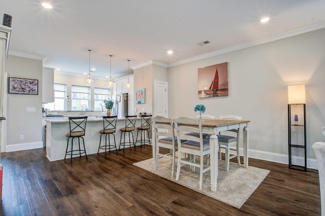 dining room featuring ornamental molding, dark hardwood / wood-style flooring, and sink