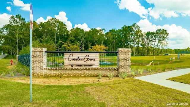 community / neighborhood sign featuring a yard