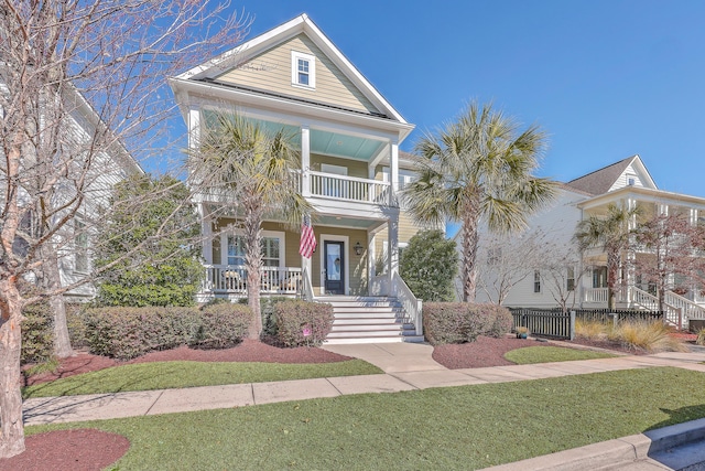 view of front of home with a porch, a balcony, and a front lawn