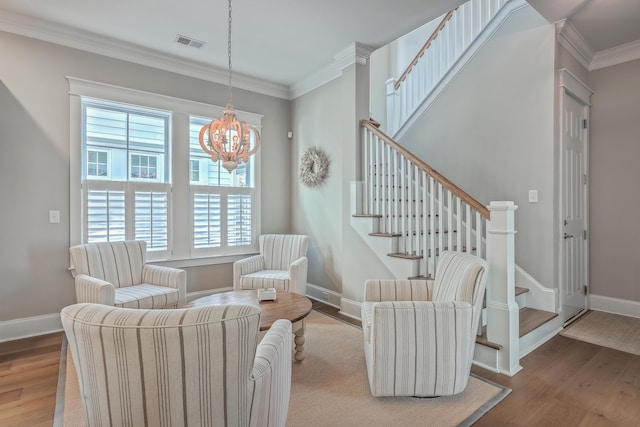 sitting room featuring baseboards, crown molding, visible vents, and wood finished floors