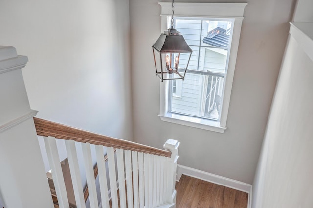 staircase with baseboards and wood finished floors