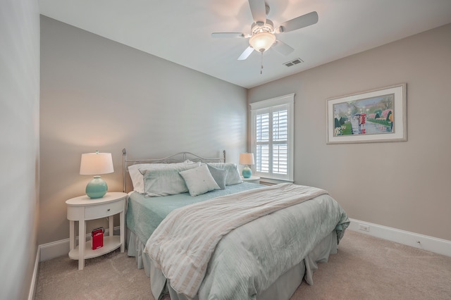 bedroom with baseboards, ceiling fan, visible vents, and light colored carpet