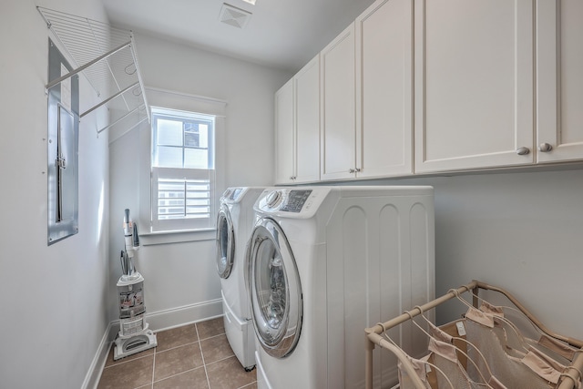 laundry area with washer and clothes dryer, light tile patterned floors, visible vents, cabinet space, and baseboards