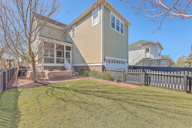 rear view of house featuring a lawn, a sunroom, a fenced backyard, stairs, and a gate