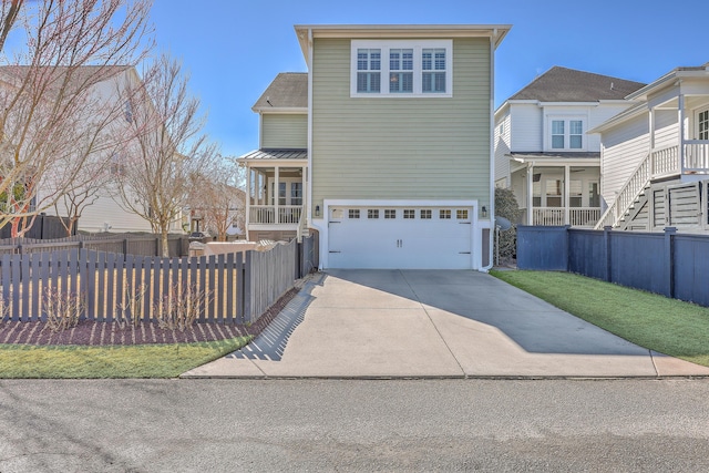 view of front facade featuring metal roof, fence, driveway, and an attached garage