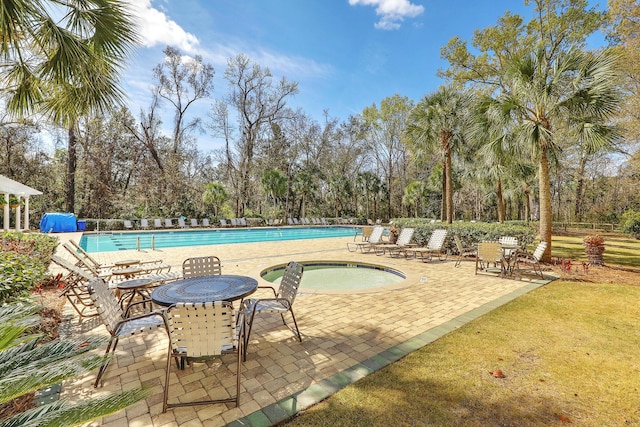 community pool featuring a patio area and a hot tub