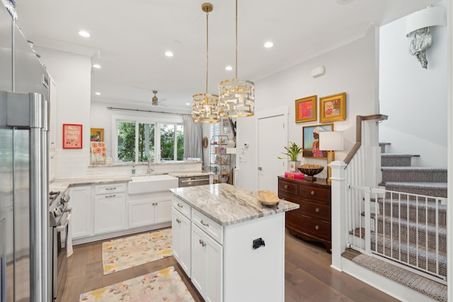 137 Bratton Cir, Mount Pleasant, SC 29464 - kitchen featuring a sink, wood finished floors, a center island, light stone countertops, and white cabinetry