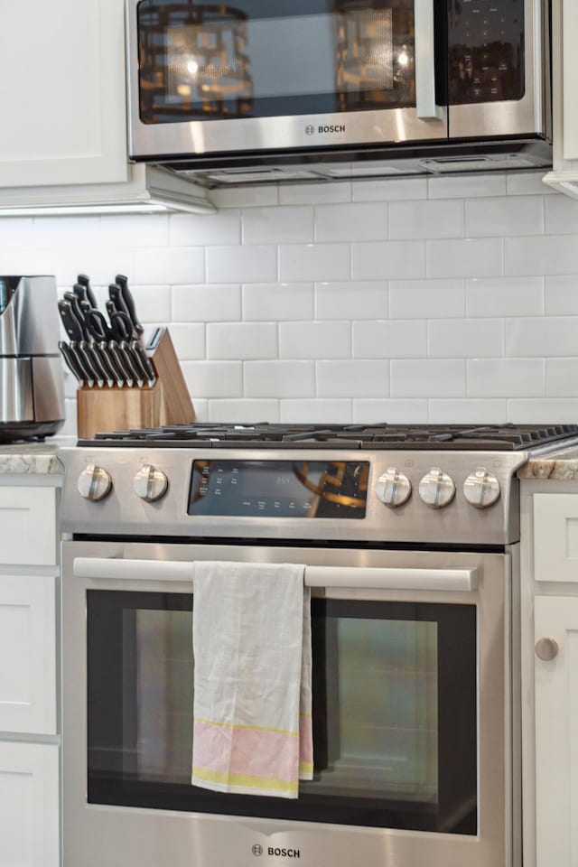 137 Bratton Cir, Mount Pleasant, SC 29464 - kitchen with stainless steel appliances, white cabinets, and tasteful backsplash