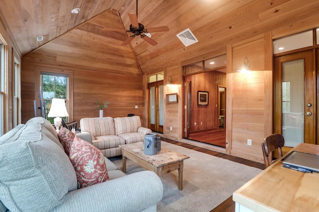 living area featuring vaulted ceiling, wood ceiling, wood walls, and visible vents