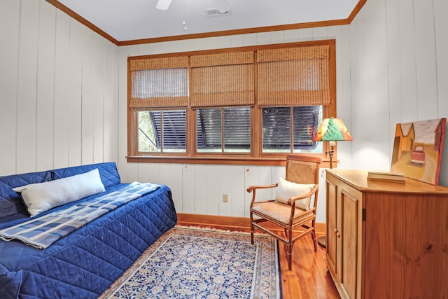 bedroom featuring light wood finished floors, visible vents, and ornamental molding