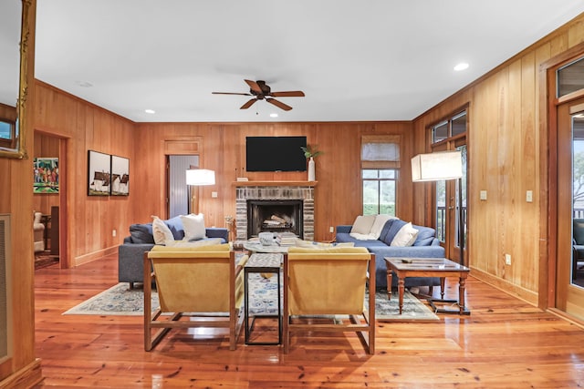 living area featuring a ceiling fan, recessed lighting, a brick fireplace, and light wood finished floors