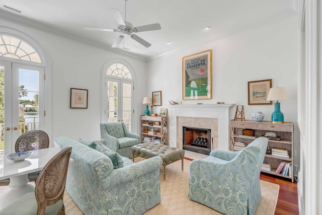 living area with ornamental molding, a high end fireplace, visible vents, and french doors