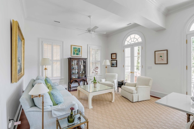 living room featuring baseboards, visible vents, ornamental molding, and a ceiling fan