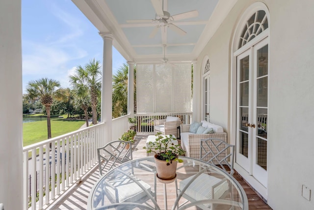 balcony with a ceiling fan, a water view, and french doors