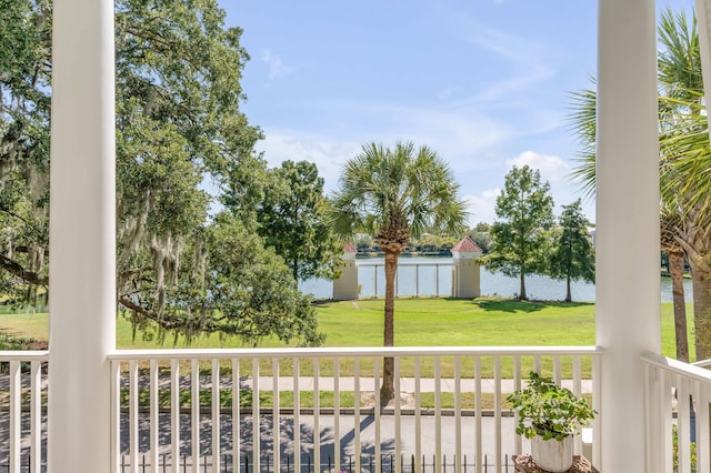 exterior space featuring a porch, a yard, and a water view
