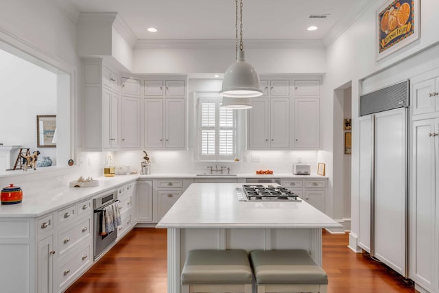 kitchen featuring a sink, stainless steel appliances, crown molding, white cabinetry, and light countertops