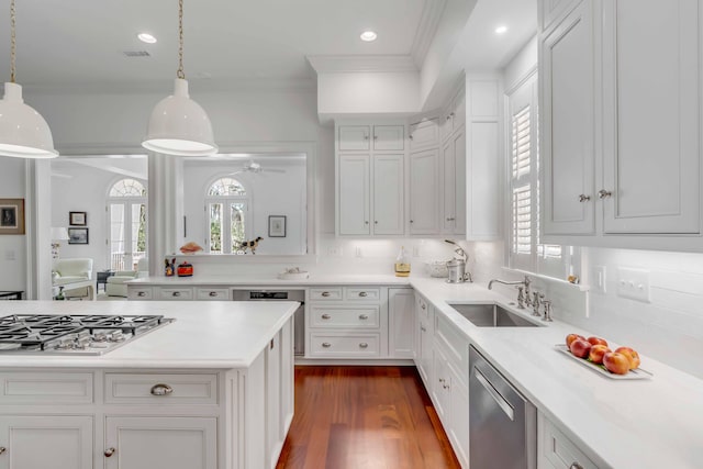 kitchen featuring a sink, light countertops, ornamental molding, white cabinets, and appliances with stainless steel finishes