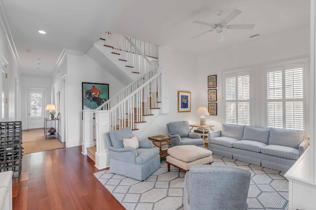 living area featuring visible vents, ceiling fan, ornamental molding, wood finished floors, and stairs