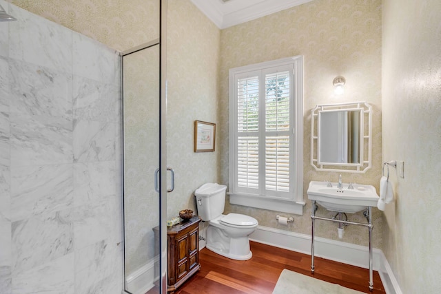 bathroom featuring toilet, a shower with shower door, baseboards, ornamental molding, and wood finished floors