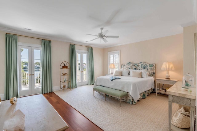 bedroom with wood finished floors, access to exterior, visible vents, french doors, and crown molding