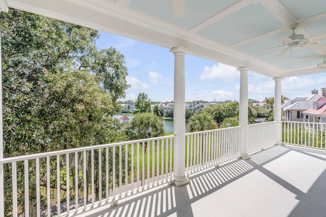 exterior space with a balcony, a water view, and ceiling fan