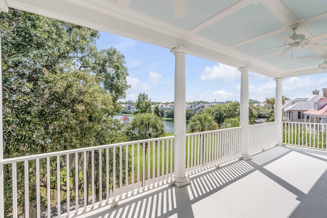 balcony with ceiling fan and a water view