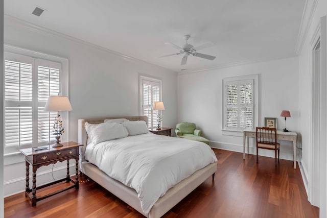 bedroom with crown molding, visible vents, wood finished floors, and baseboards