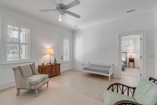 sitting room with light tile patterned flooring, ceiling fan, crown molding, visible vents, and baseboards