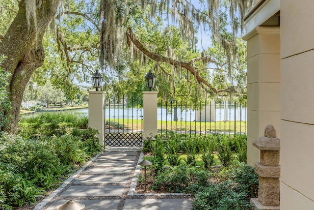 view of gate featuring fence and a water view