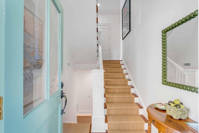 staircase featuring visible vents and baseboards