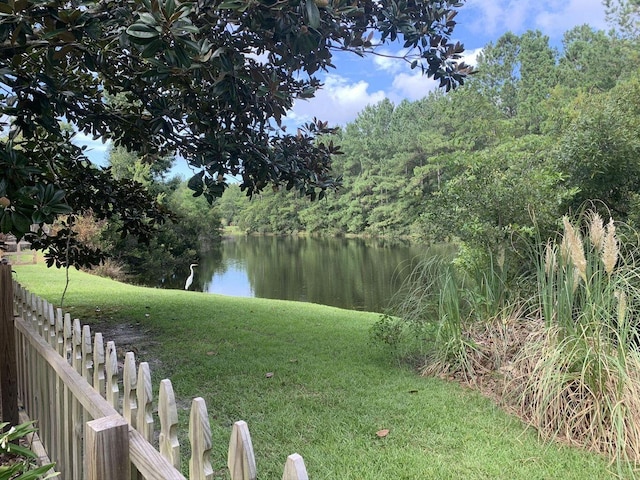 view of yard featuring a water view and fence