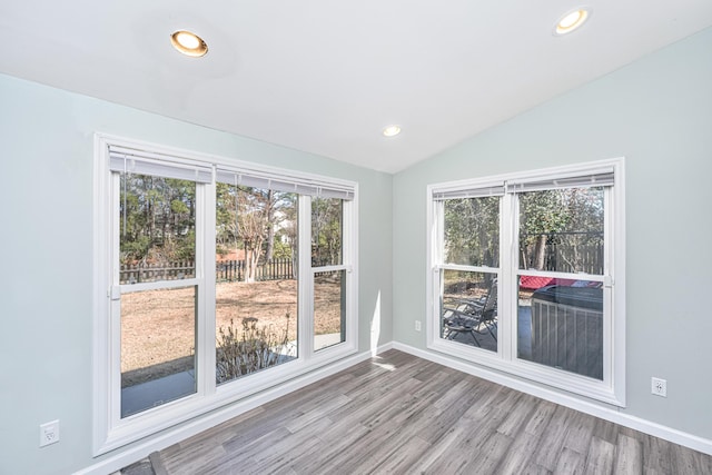 spare room with vaulted ceiling, baseboards, wood finished floors, and recessed lighting