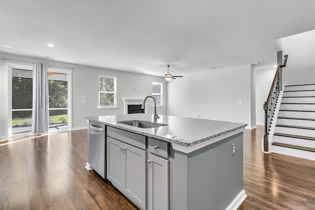 kitchen with dark wood-type flooring, sink, gray cabinetry, and a center island with sink