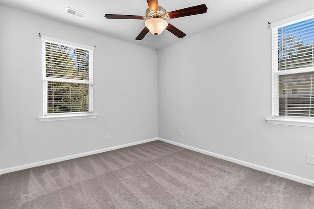 carpeted empty room featuring plenty of natural light and ceiling fan