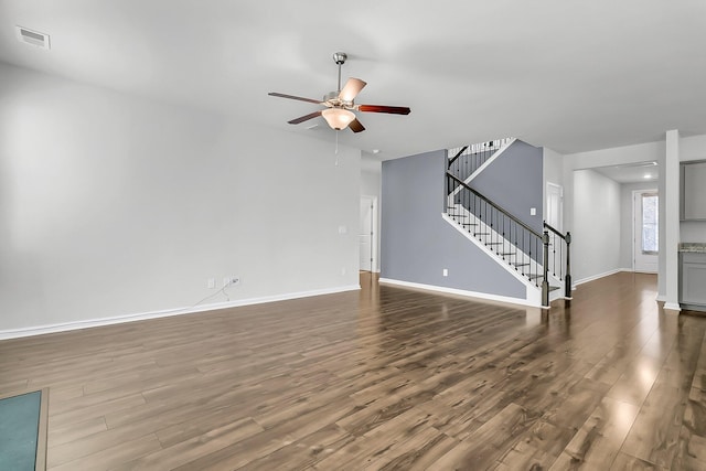 unfurnished living room featuring ceiling fan and dark hardwood / wood-style flooring