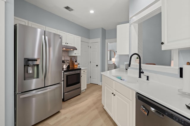 1179 Holly Bend Dr, Mount Pleasant, SC 29466 - kitchen featuring appliances with stainless steel finishes, a sink, under cabinet range hood, light countertops, and white cabinets