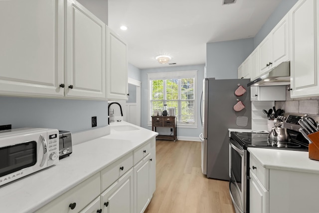 1179 Holly Bend Dr, Mount Pleasant, SC 29466 - kitchen with stainless steel appliances, a sink, under cabinet range hood, light wood-style flooring, and white cabinets