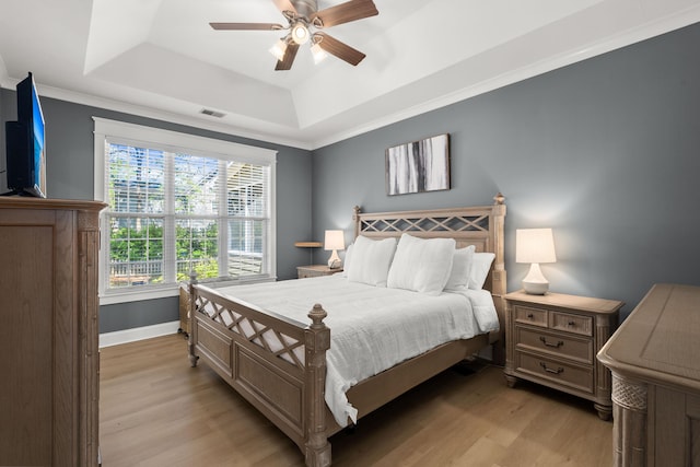 1179 Holly Bend Dr, Mount Pleasant, SC 29466 - bedroom featuring a raised ceiling, light wood-style flooring, a ceiling fan, baseboards, and crown molding