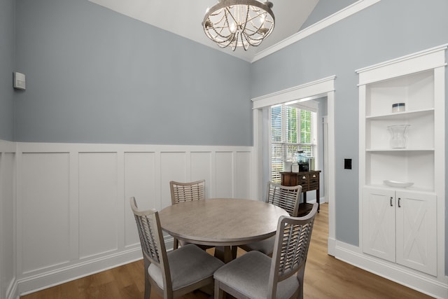 1179 Holly Bend Dr, Mount Pleasant, SC 29466 - dining room featuring lofted ceiling, a chandelier, wood finished floors, a wainscoted wall, and a decorative wall