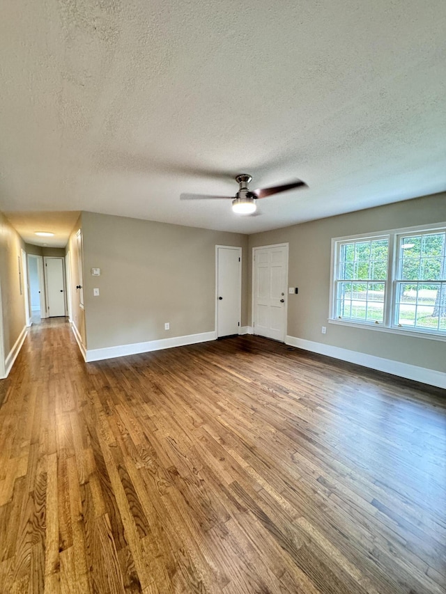 spare room featuring wood-type flooring, a textured ceiling, and ceiling fan