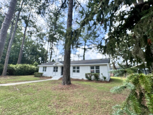 single story home featuring a front lawn