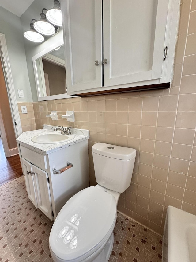 bathroom with vanity, toilet, tile patterned flooring, and tile walls