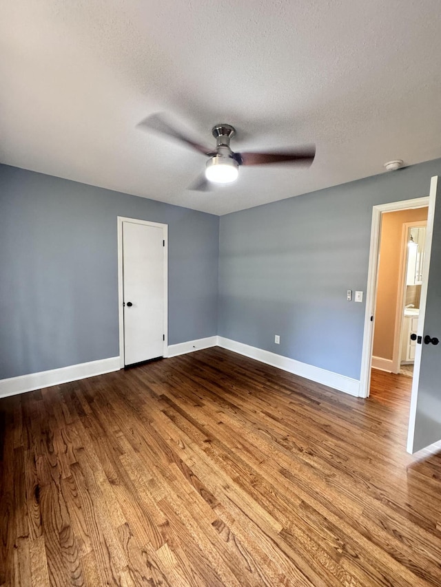 spare room with ceiling fan, a textured ceiling, and light wood-type flooring