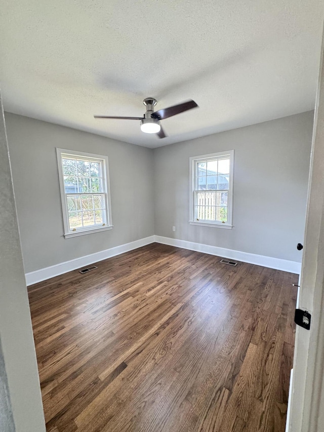 unfurnished room featuring ceiling fan, dark hardwood / wood-style flooring, and a textured ceiling