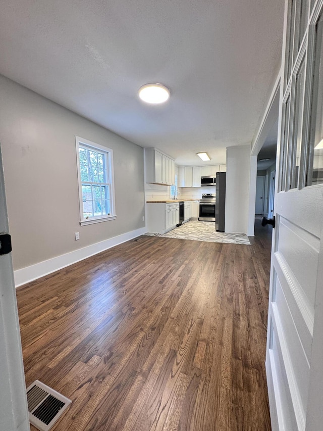 unfurnished living room featuring dark hardwood / wood-style floors