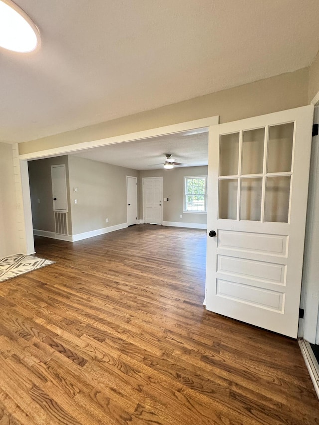 unfurnished living room featuring ceiling fan and wood-type flooring