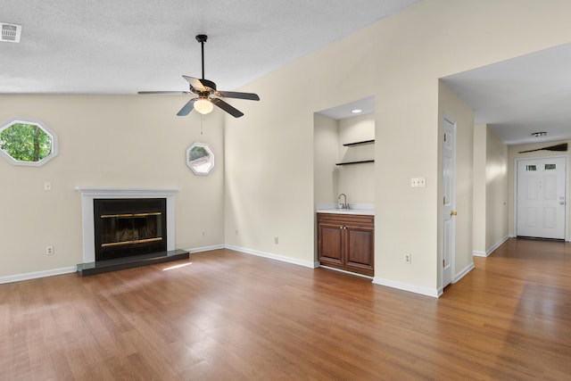 4162 Murrells Inlet Rd, Murrells Inlet, SC 29576 - unfurnished living room with wood finished floors, a ceiling fan, a glass covered fireplace, and baseboards